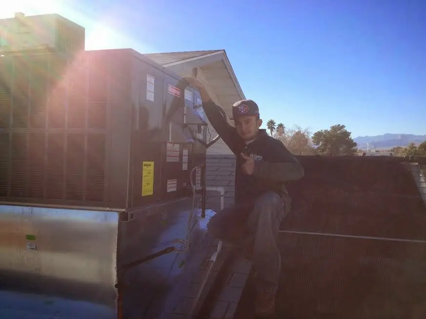 HVAC technician performing Air Duct Cleaning on a rooftop unit in Skiatook